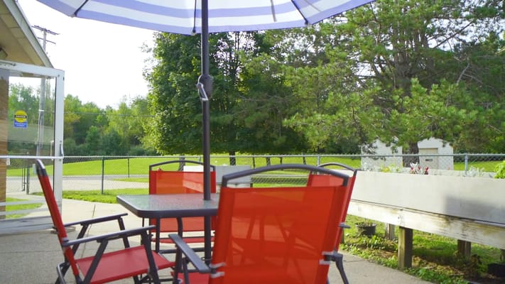Outdoor patio area with red chairs and umbrella