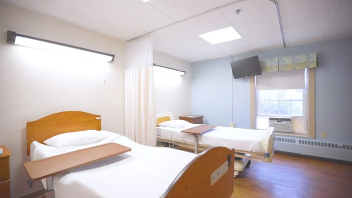 A shared resident room with two beds and a window