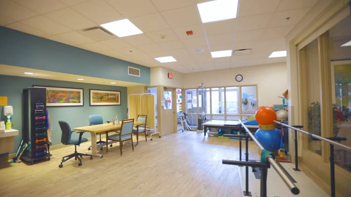 Rehabilitation therapy room with equipment and chairs