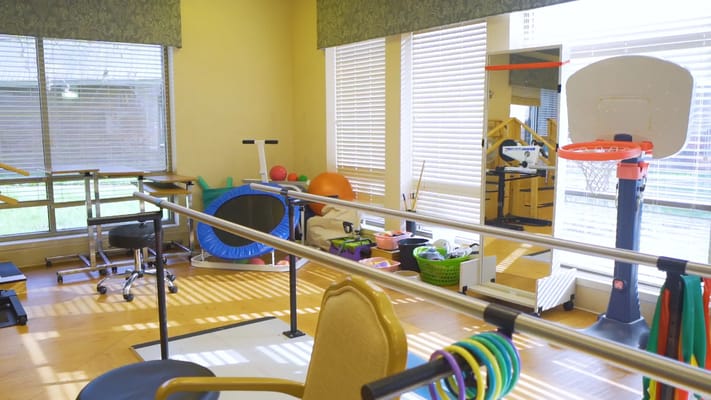 A bright activity room with therapy equipment