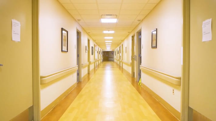 A well-lit corridor with framed pictures on the walls