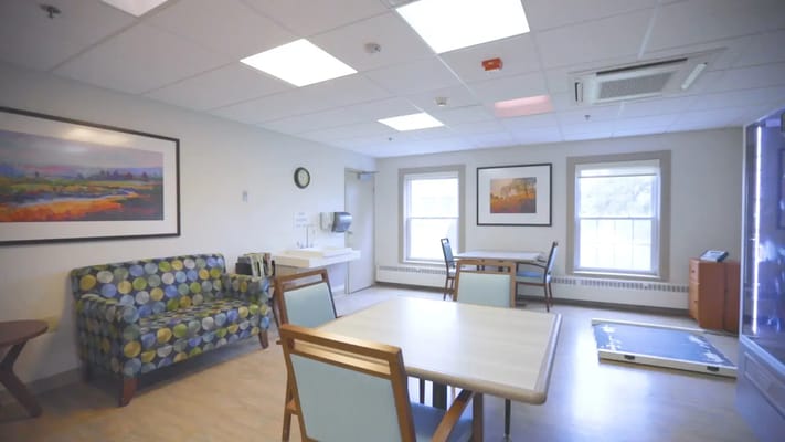 Bright, comfortable common area with seating and paintings