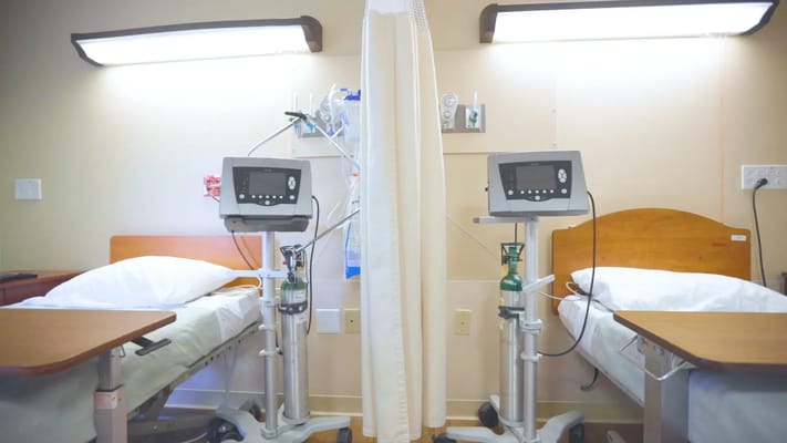 Two hospital beds in a patient room