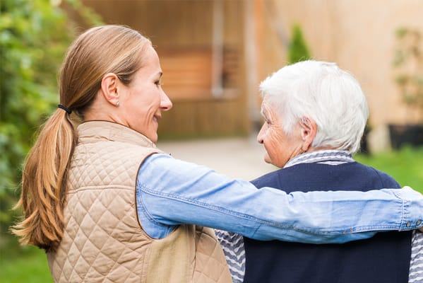 Staff member embracing a resident outdoors