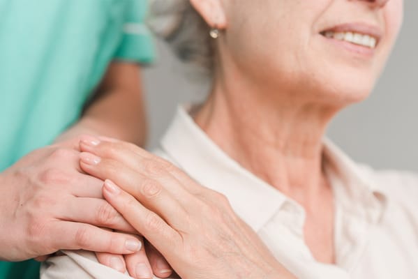 Close-up of a caregiver assisting an elderly woman