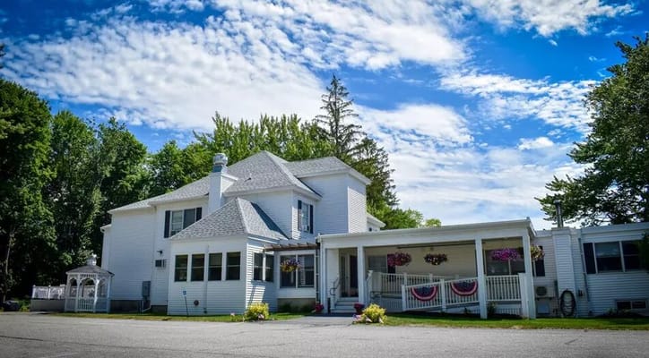 Exterior view of Capitol City Manor with gardens and flag decorations
