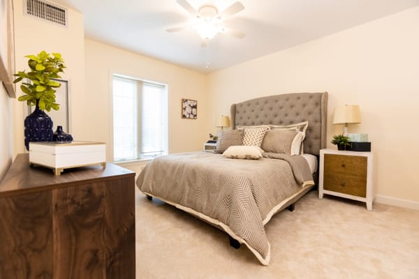 A well-decorated bedroom with a large bed, bedside tables, and natural light.