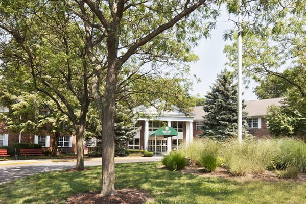 Front view of The Grove at Oakleaf Village with trees and garden