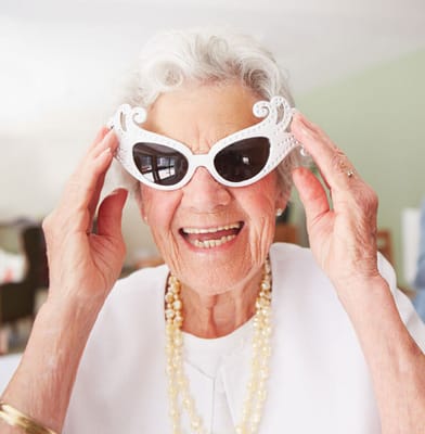 Senior woman wearing playful sunglasses and smiling