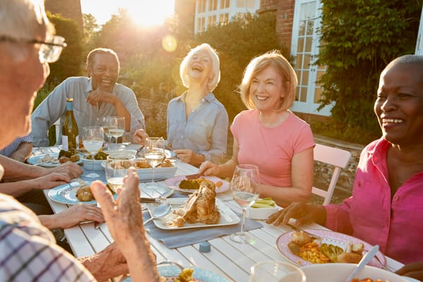 Group of residents enjoying a meal in an outdoor setting