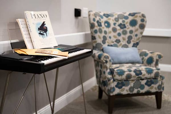 Cozy interior with piano and floral chair