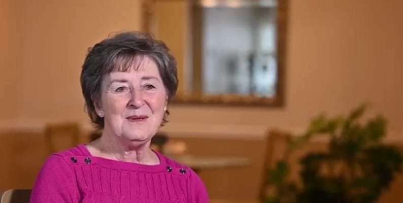 Senior resident smiling in a well-lit interior
