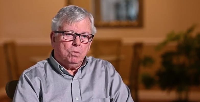 An elderly man speaking in a common area