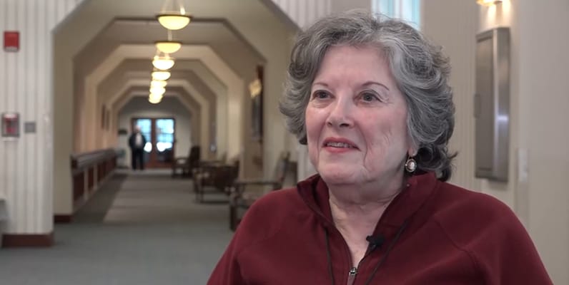 Resident smiling in a well-lit hallway