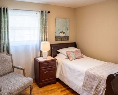 Cozy private room with a bed and chair