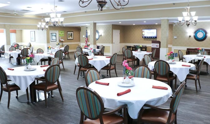 Dining room set for meals with flowers on tables