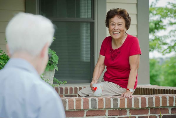 A resident laughing while enjoying a drink outdoors