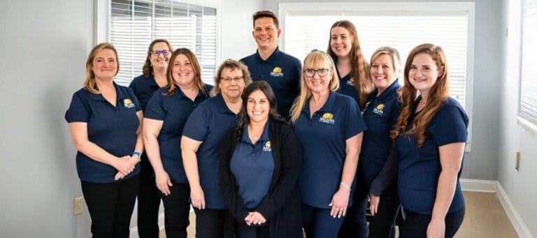 Staff members posing together in a bright room
