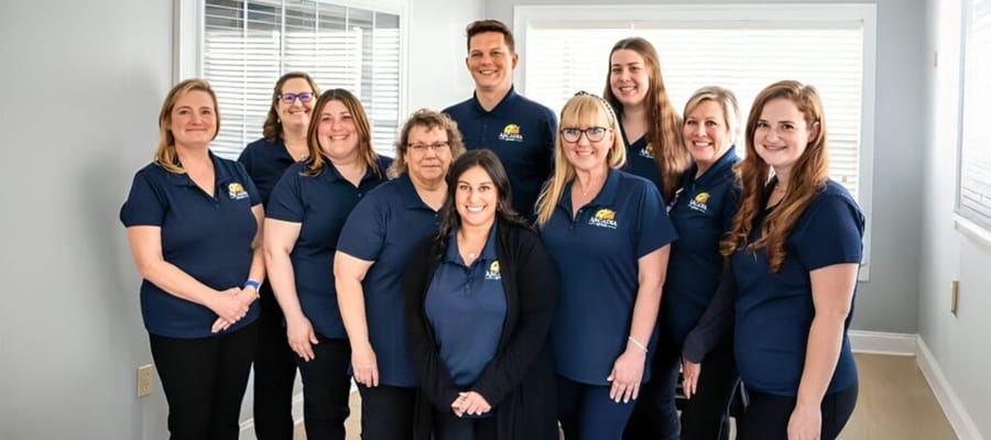 Staff members posing together in a bright room