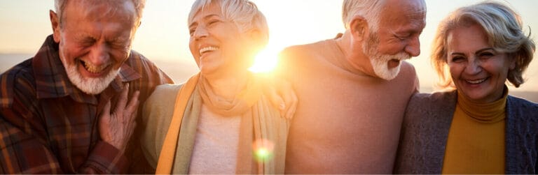 Seniors laughing together during a sunset