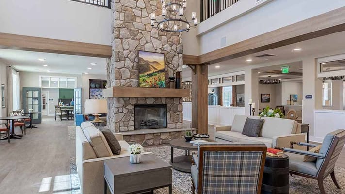 Bright and welcoming common area with a stone fireplace