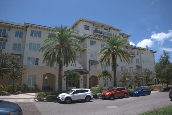 Exterior view of a senior living facility with palm trees