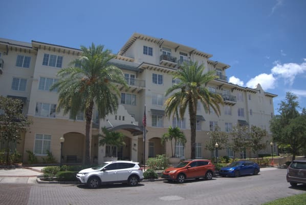 Exterior view of a senior living facility with palm trees