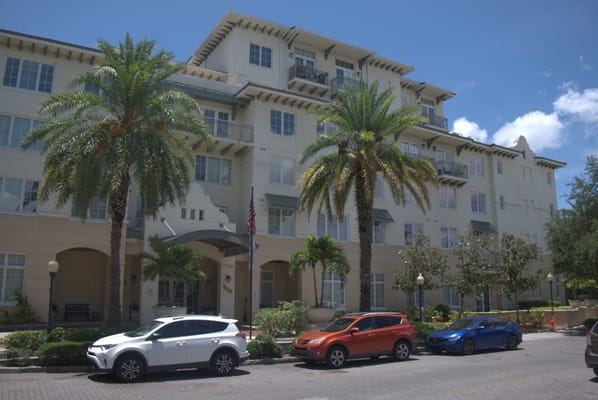 Exterior view of a senior living facility with palm trees