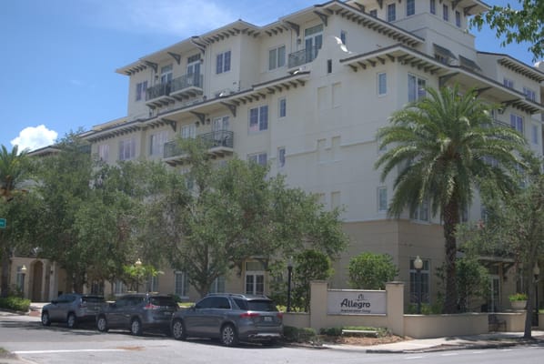 Exterior view of a senior living facility with palm trees