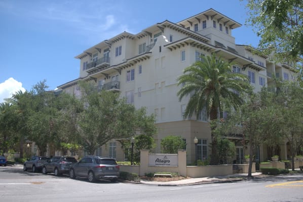 Exterior view of a senior living facility with palm trees