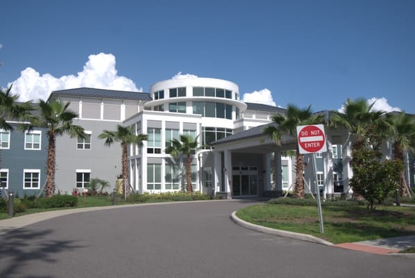 Exterior view of a nursing home facility with palm trees