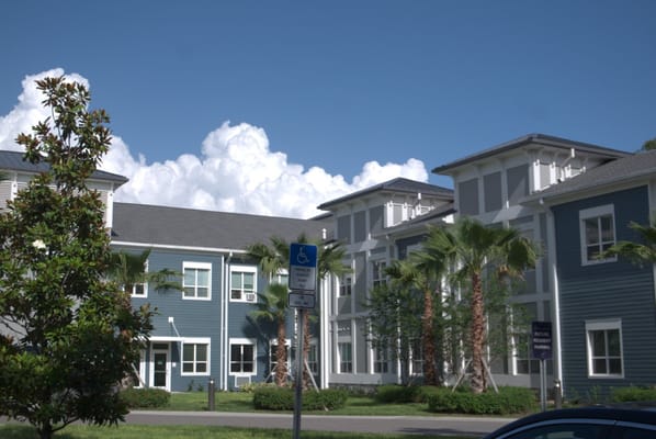 Exterior view of a senior living facility with palm trees