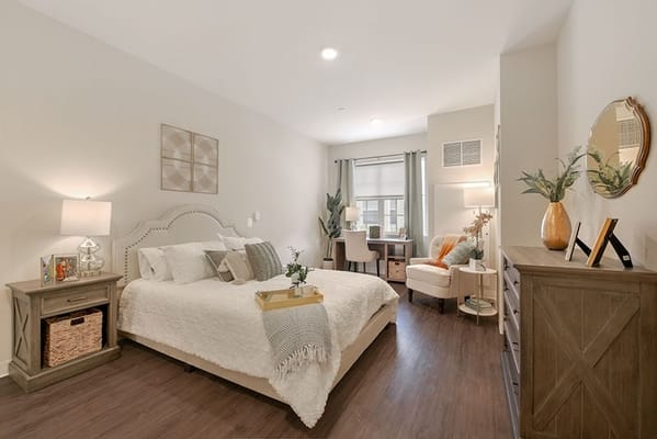 Spacious bedroom with a bed, bedside table, and desk