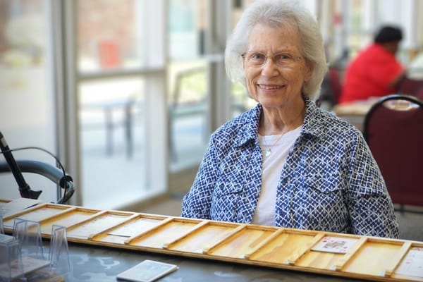 Resident smiling during a game in the activity room
