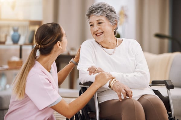 Caregiver interacting with a smiling senior in a common area