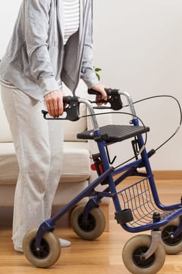 Close-up of a person using a walker indoors