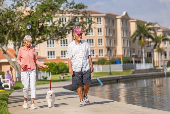 Residents walking a dog along the waterfront path