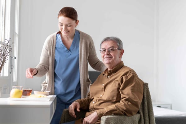 Caregiver serving snacks to a resident in a cozy room