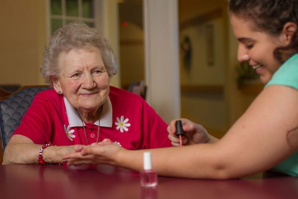 An elderly resident receiving a manicure from staff