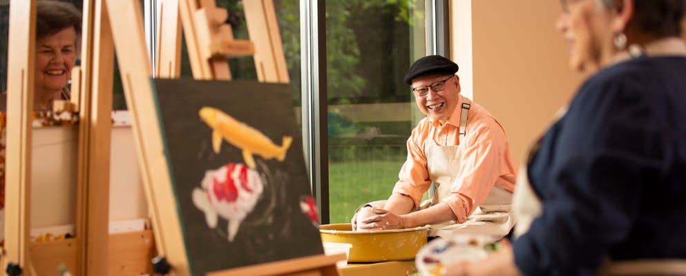 Residents engaging in a pottery activity with laughter