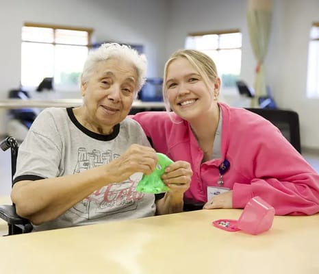 Resident and staff member enjoying a craft activity