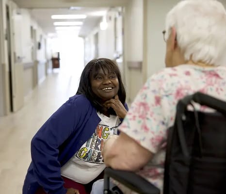 Staff member engaging with a resident in a hallway