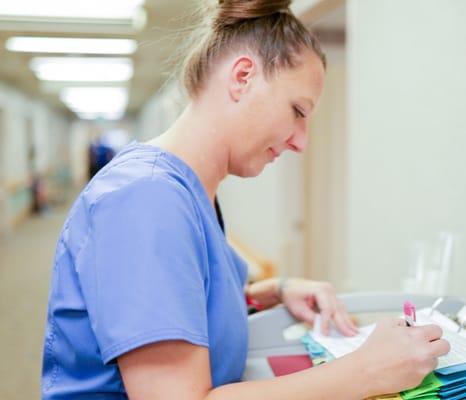 Staff member engaged in care tasks in a hallway
