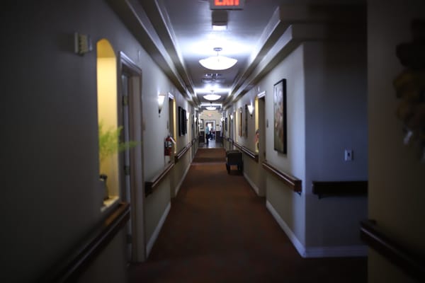Hallway in an assisted living facility with residents visible