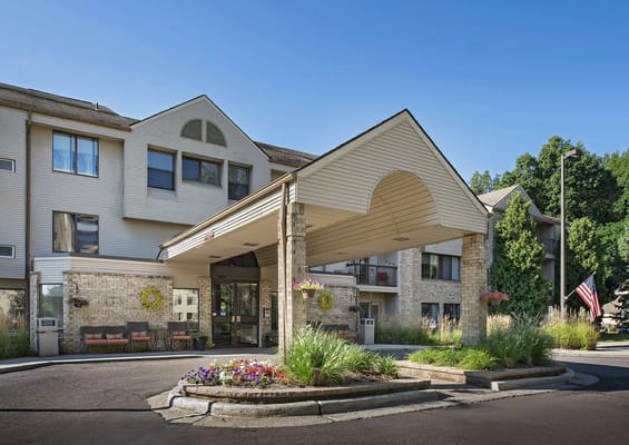 Entrance of a senior living facility with flower beds