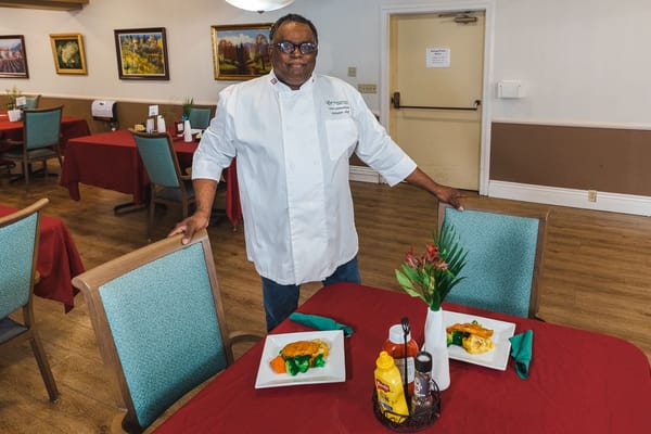 Chef presenting plated meals in the dining area