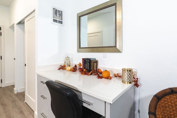 A well-decorated resident room with a desk and autumn decor