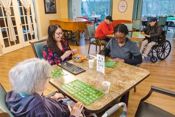 Residents playing bingo in a bright common area