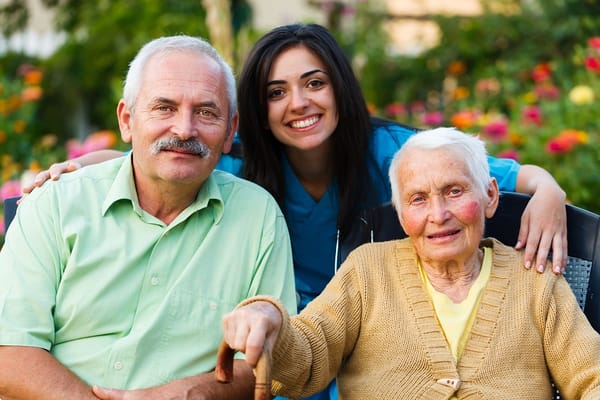 Senior residents with staff member in a garden