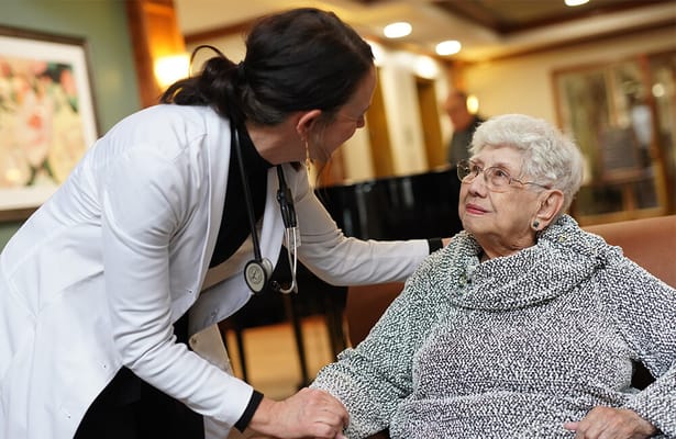 Nurse interacting with a resident in a cozy facility lounge